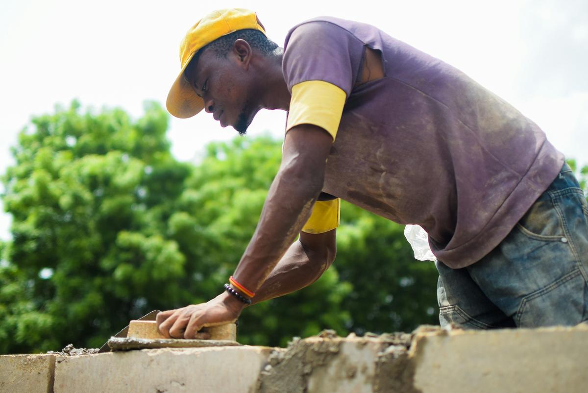 Mason laying blocks on a wall during construction
