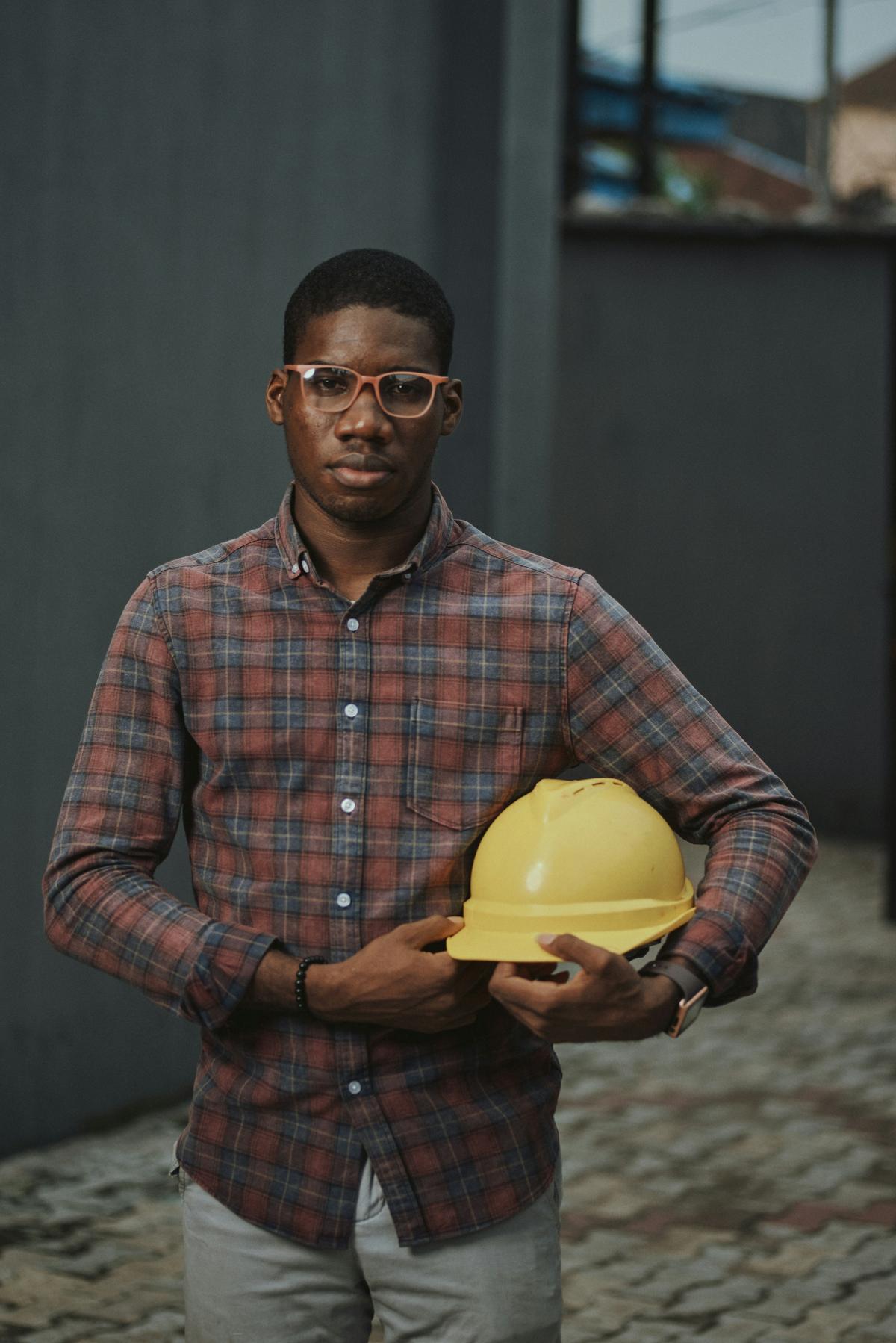 Construction professional holding a yellow safety helmet