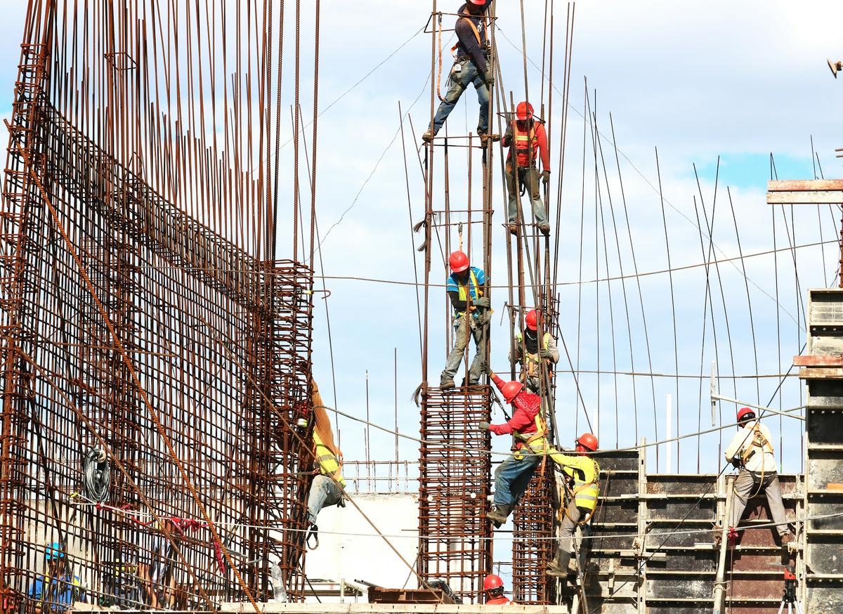 Workers fixing steel reinforcement for concrete columns on a building site