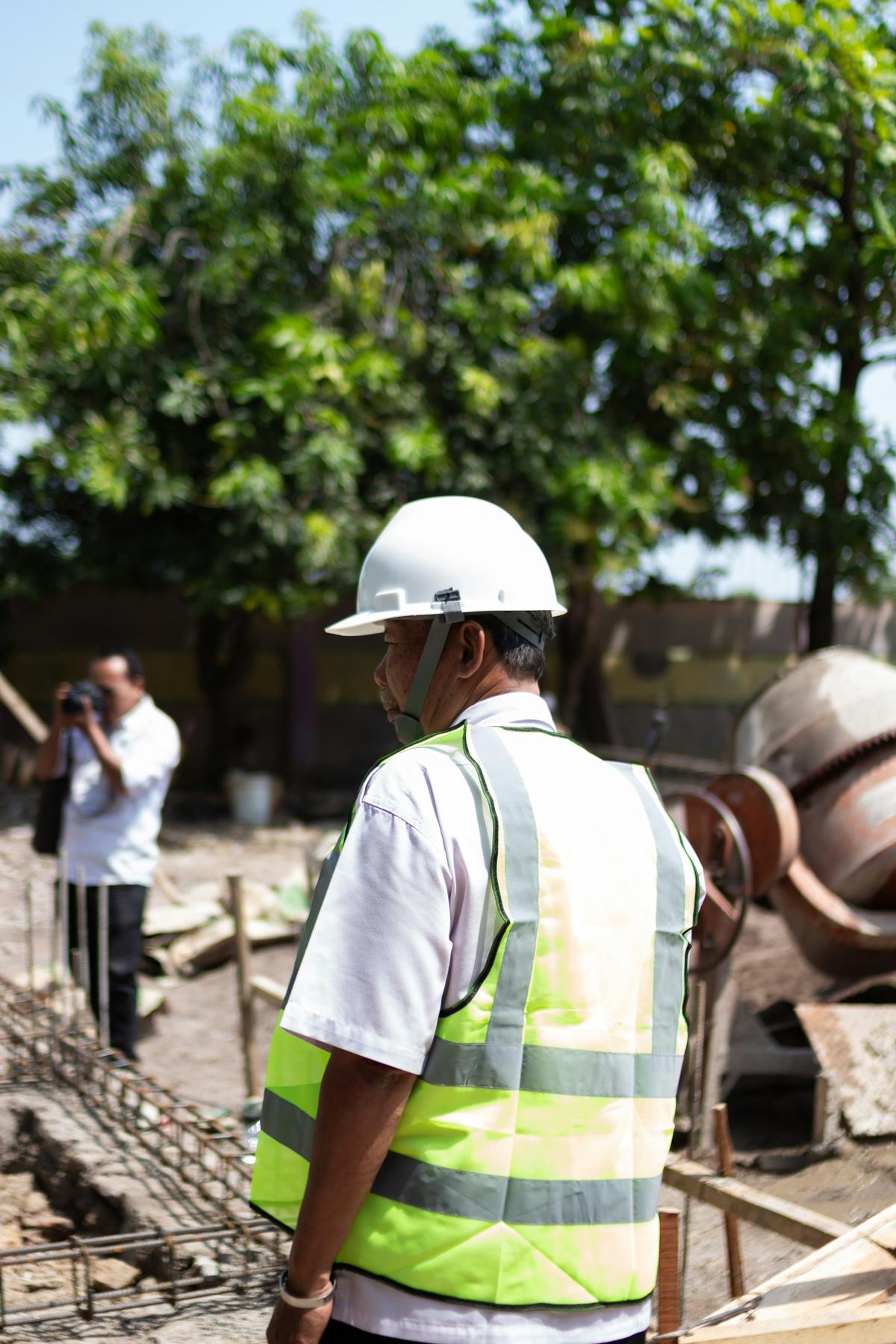 Site engineer wearing a white safety helmet and reflective vest on a construction site