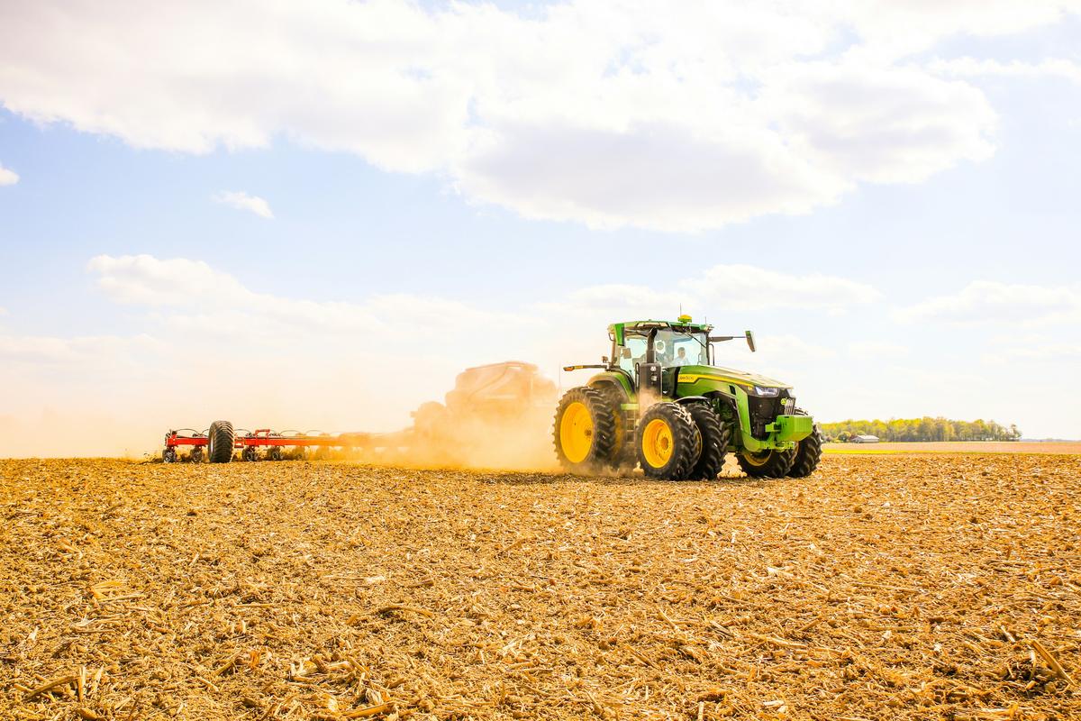 Tractor preparing a large field under an open sky