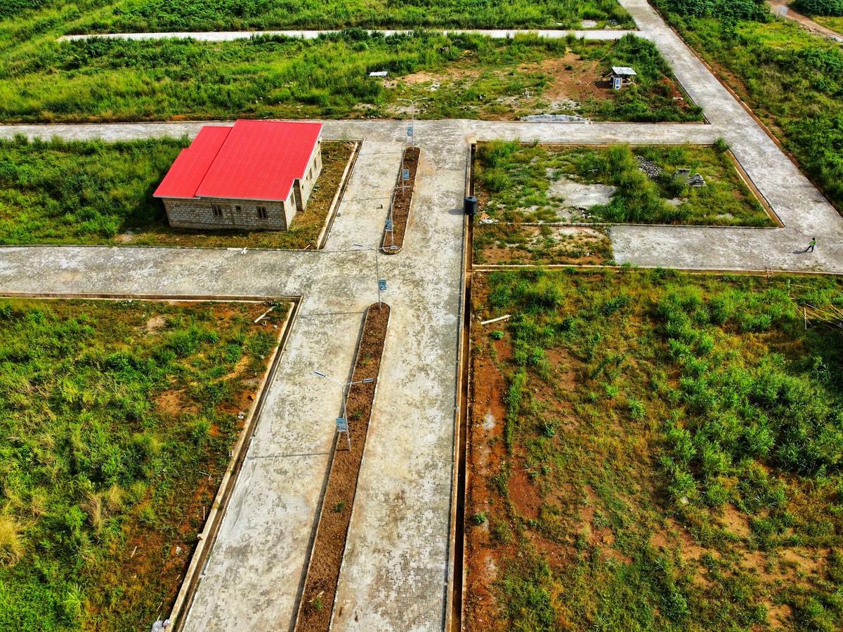 Aerial view of an estate entrance and road network across undeveloped plots