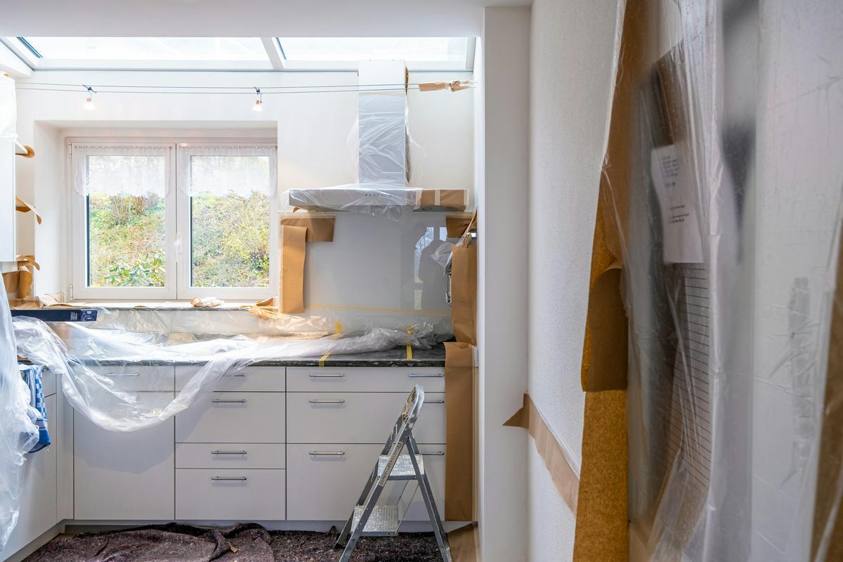 Kitchen in the middle of renovation with new cabinets protected by plastic sheeting